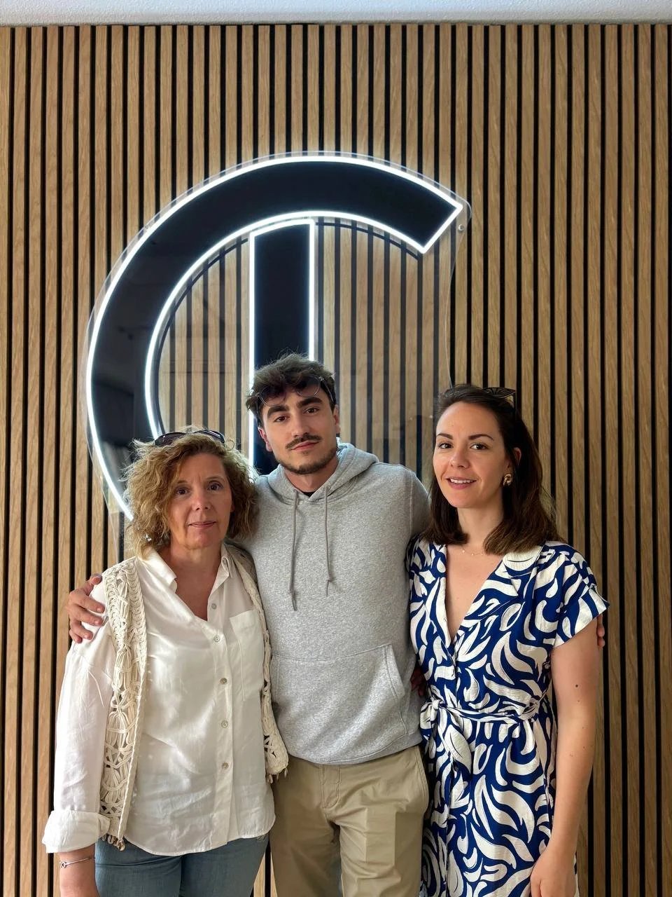 Marie, Léo et Mathilde devant le logo de La Conciergerie Lyonnaise